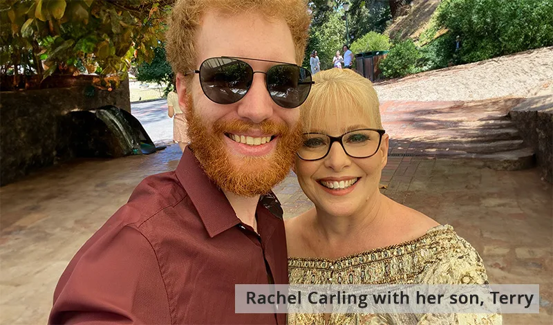 Bearded young man in sunglasses smiles with a woman in glasses.